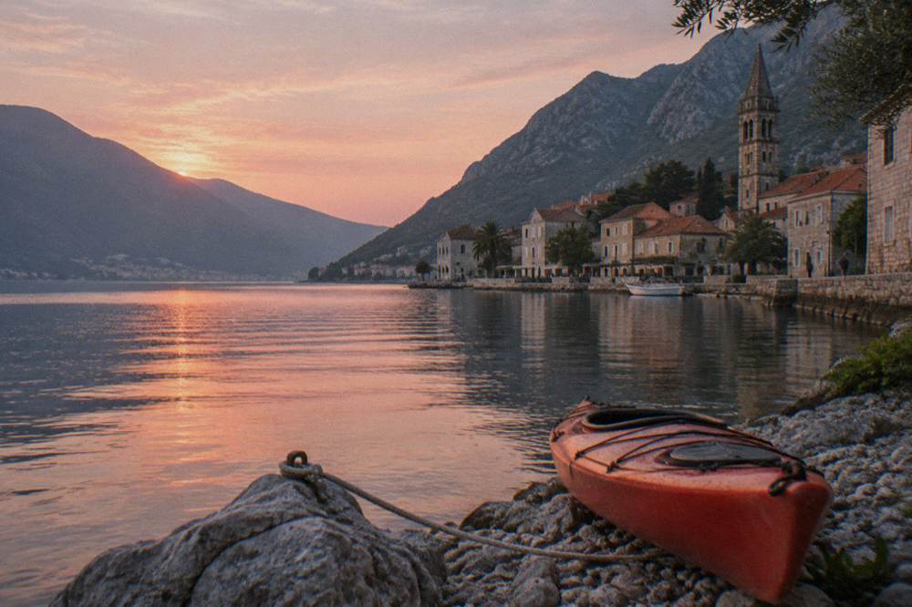 Sunrise light on calm water between dark mountains in a narrow bay