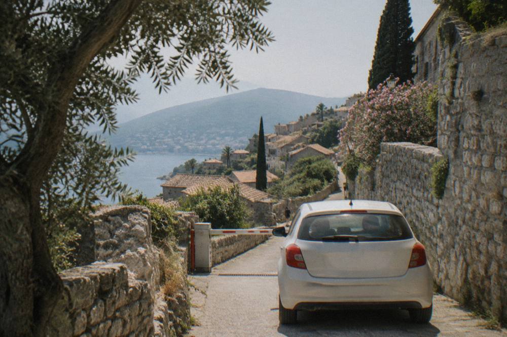 Car waiting in a queue at a small border checkpoint between coastal hills