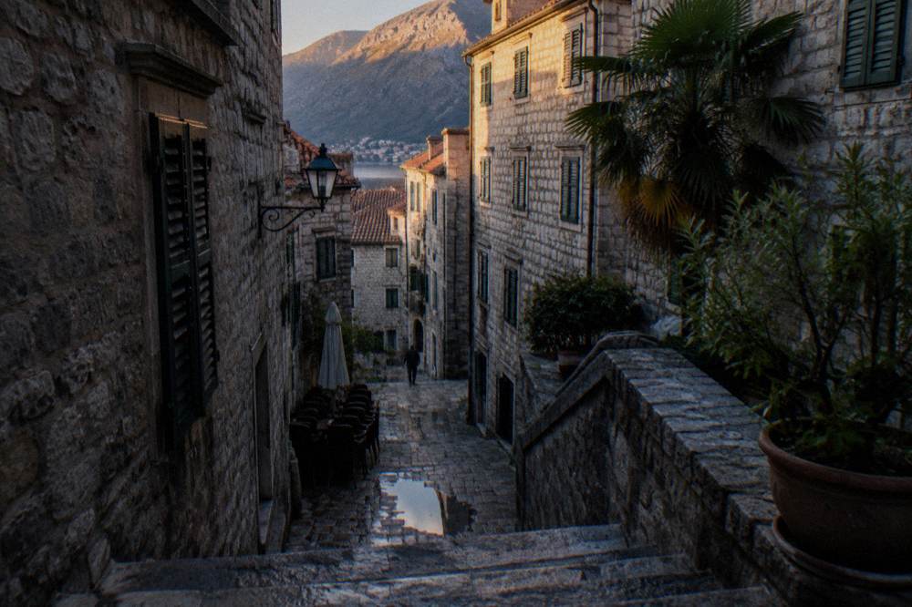 Narrow stone street inside a walled medieval town with shuttered buildings