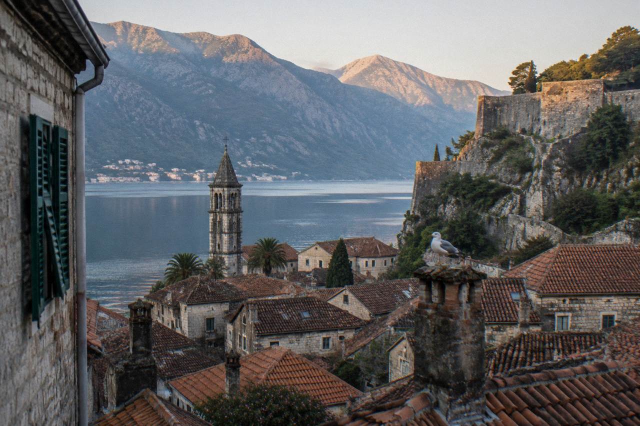Kotor Old Town rooftops and the stone walls of San Giovanni fortress rising above the bay