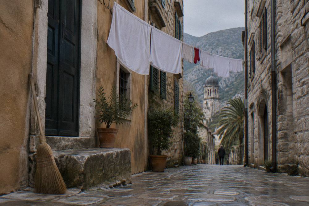 Stone lane inside Kotor Old Town with medieval facades and hanging laundry