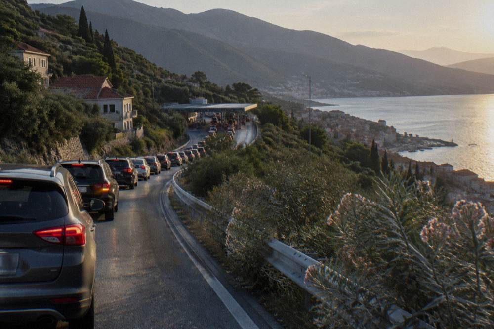 Cars queued at a border checkpoint gate in late afternoon light