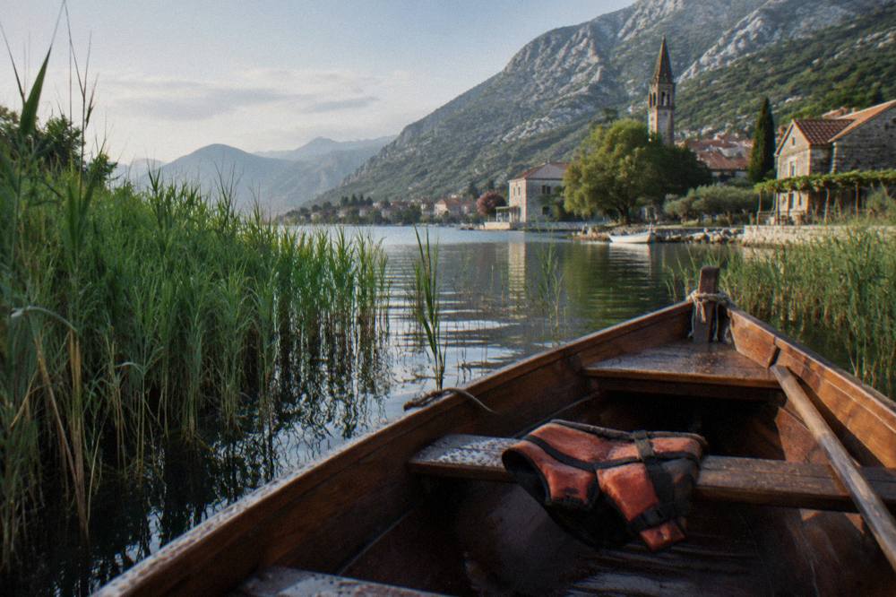Small wooden boat moored among reeds at the edge of Lake Skadar