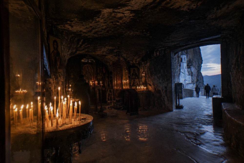 Candle glow inside a small stone chapel carved into the rock