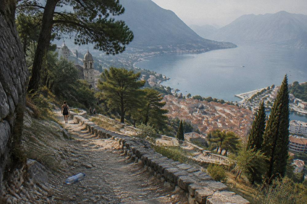 Winding stone path above Kotor with the bay and distant mountains in the background