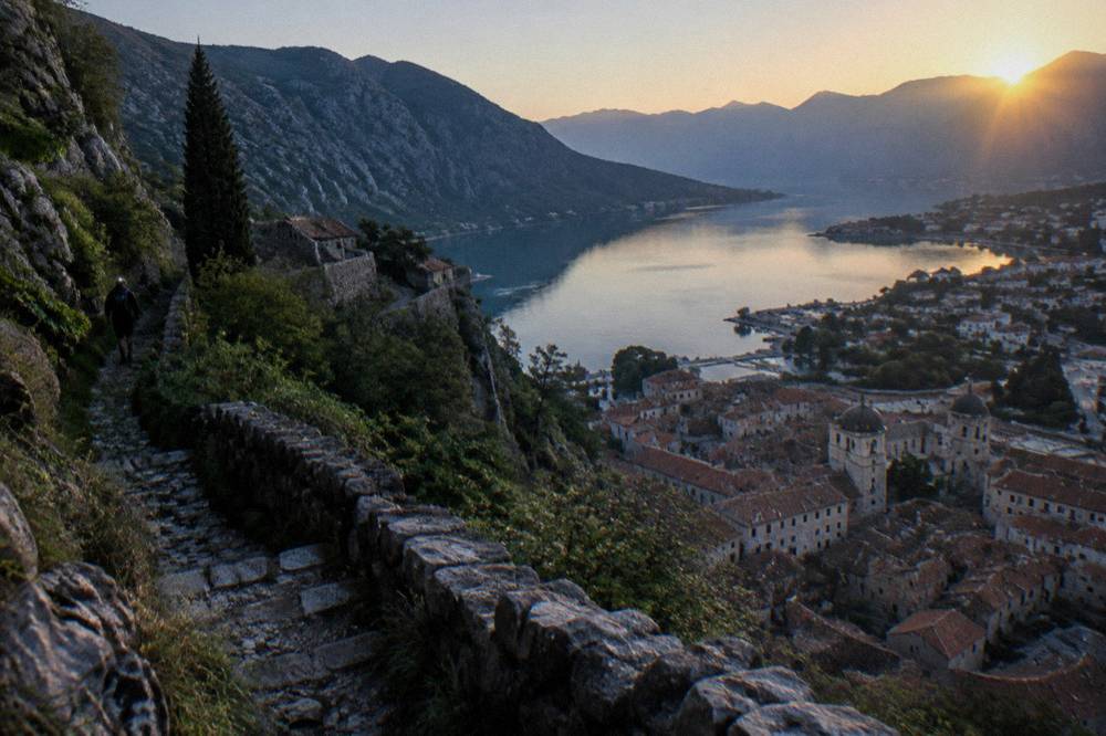 Morning light over Kotor Old Town rooftops seen from a high mountain path