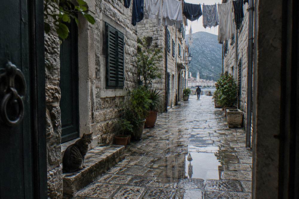 Old stone street in Kotor old town with laundry hanging above the lane
