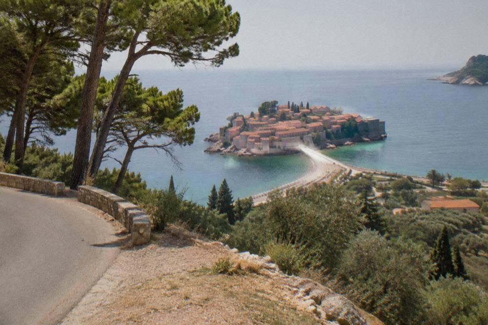 Fortified islet connected to the mainland by a narrow causeway seen from a hillside road