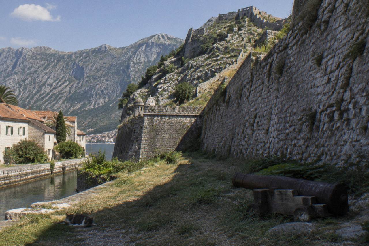 Walled old town of Kotor with mountain ridges rising above the bay at midday