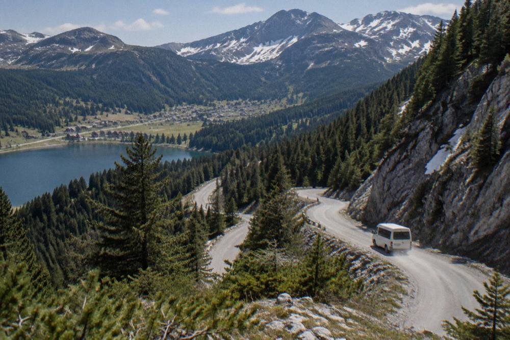 Winding mountain road climbing through pine forest toward the Durmitor plateau