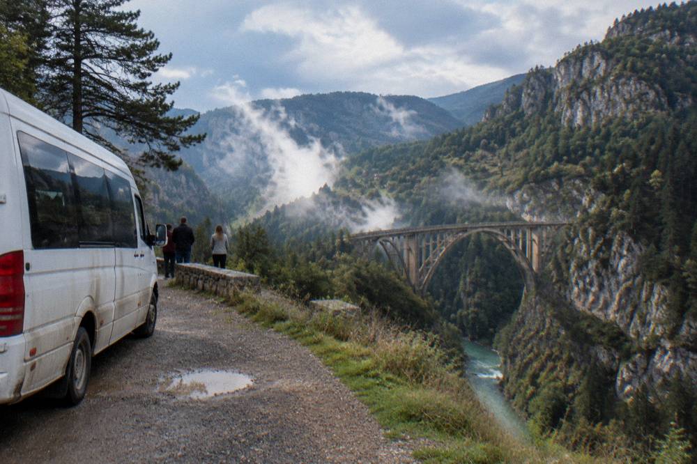 Speedboat-style tour minibus parked at a canyon viewpoint above the Tara river gorge