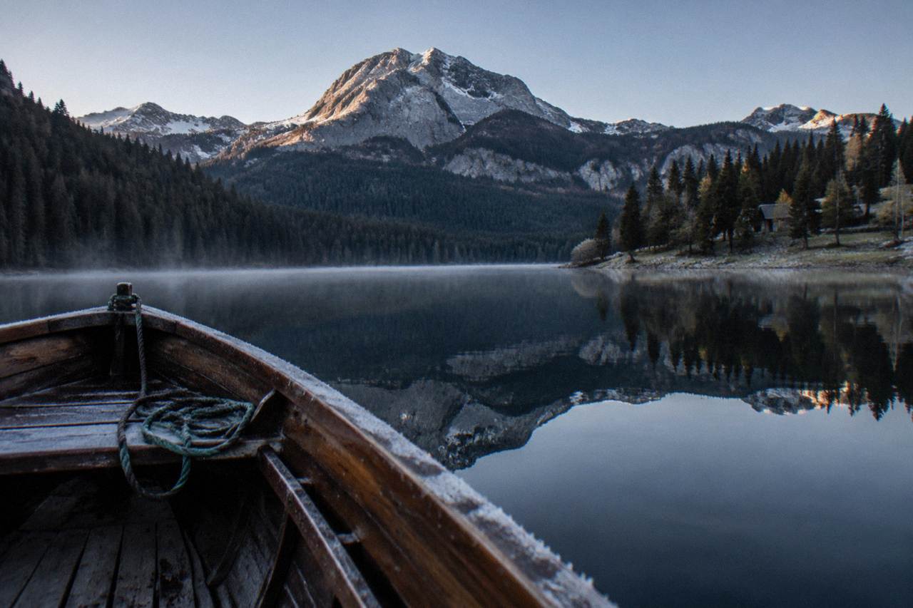 Durmitor mountain peaks reflected in the still water of Black Lake on a clear morning
