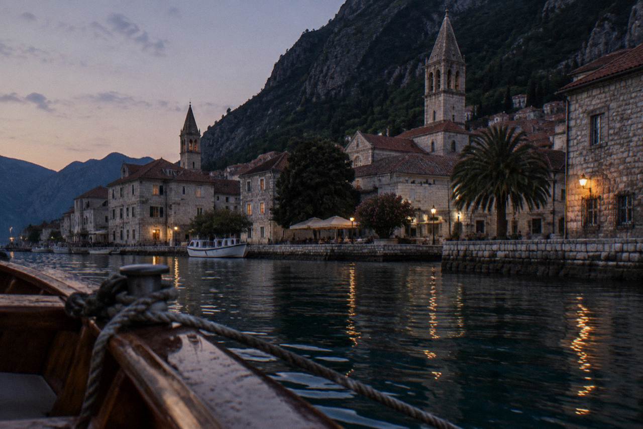 Stone buildings and church towers of Kotor Old Town seen from the water at dusk