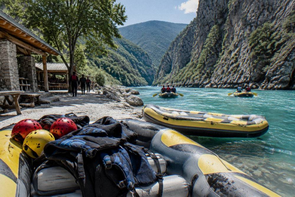 Rafts floating on turquoise river water between steep canyon cliffs