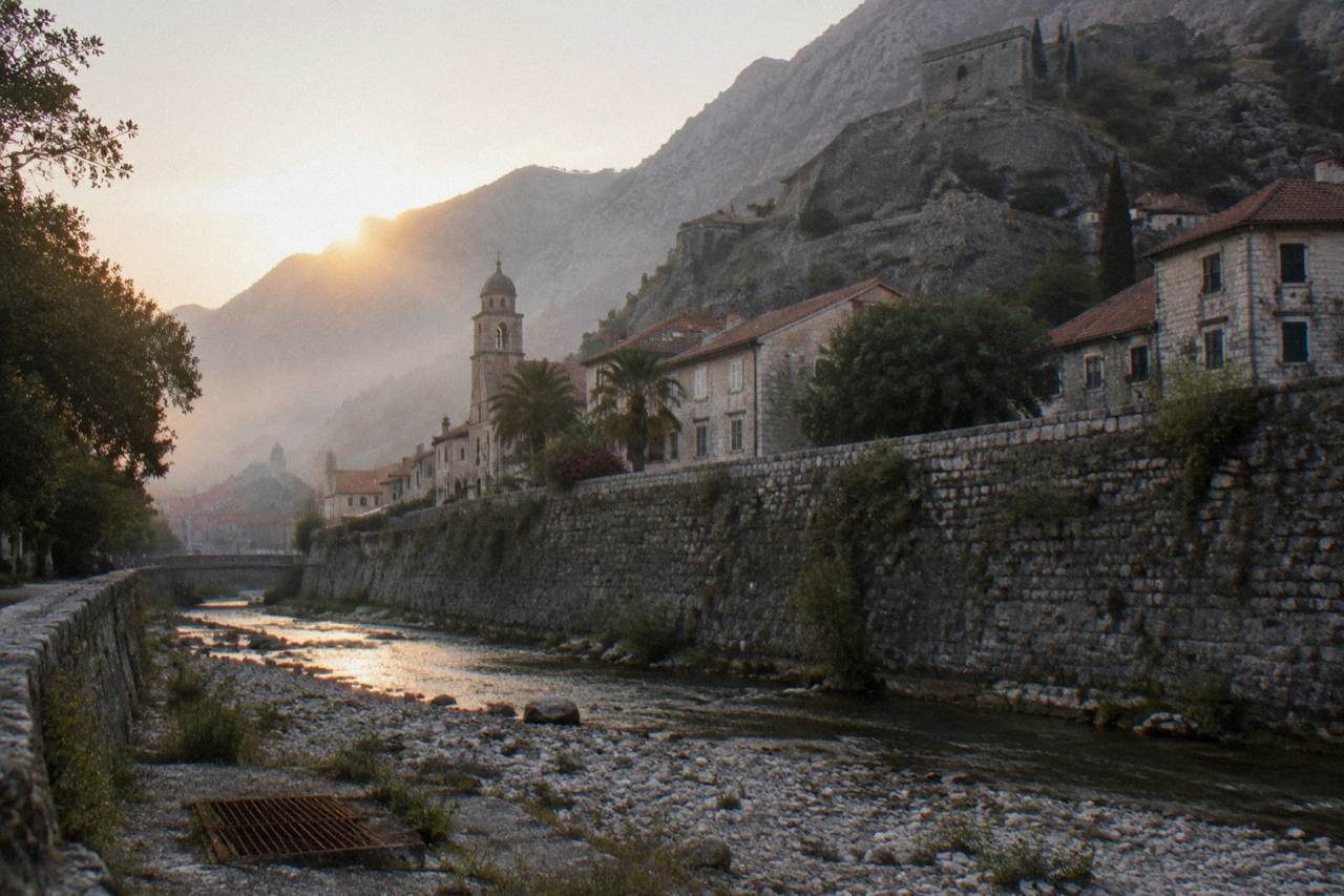 Stone ramparts of Kotor fortress rising above the red rooftops of the old town