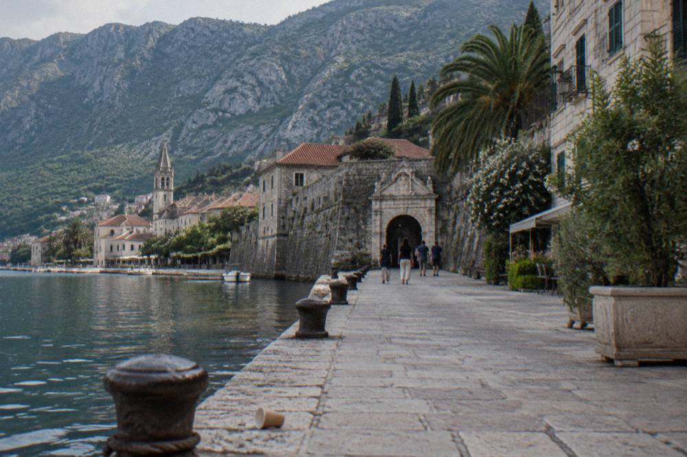 Flat stone waterfront promenade in Kotor leading toward the old town gate
