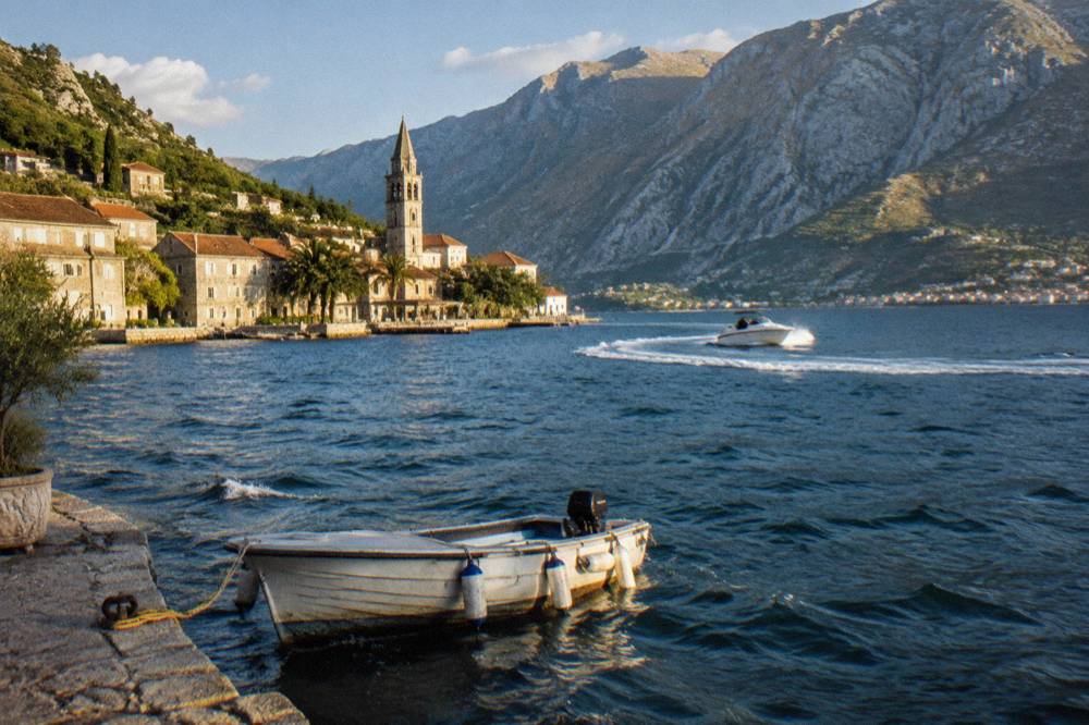 Speedboat on blue water near cliffs in the Bay of Kotor