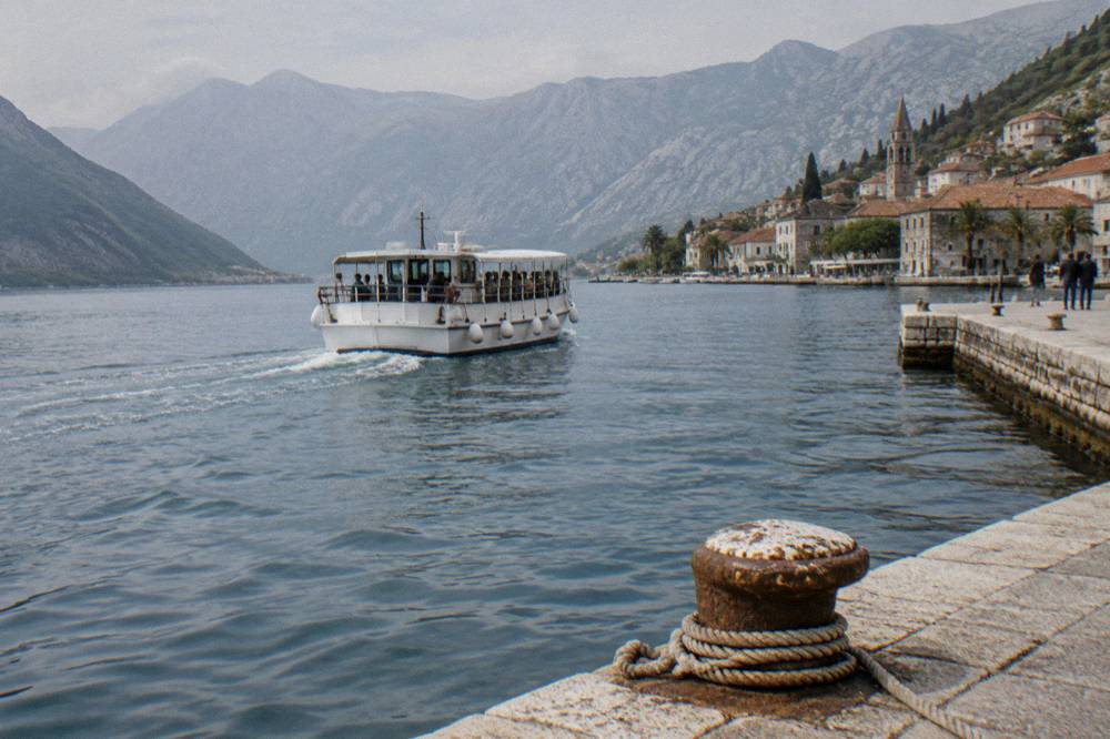 Small tender boat carrying passengers across the Bay of Kotor toward the shore