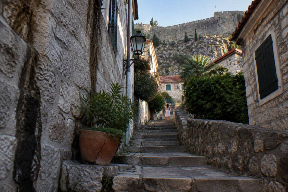 Cobbled stone lane in Kotor old town with worn steps between old stone buildings