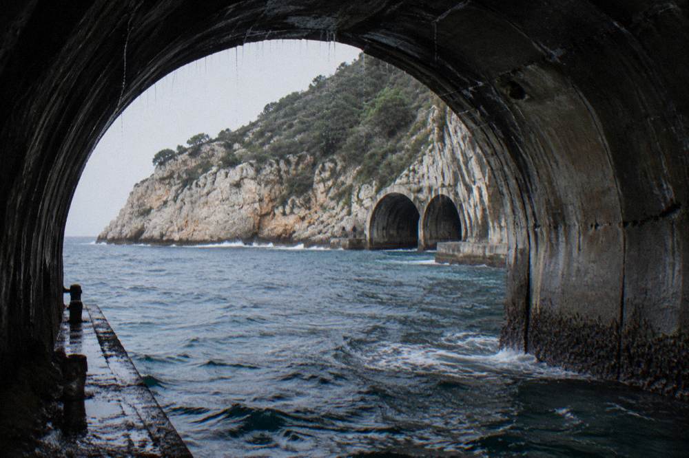 Three concrete submarine tunnels carved into a cliff on the Lustica peninsula