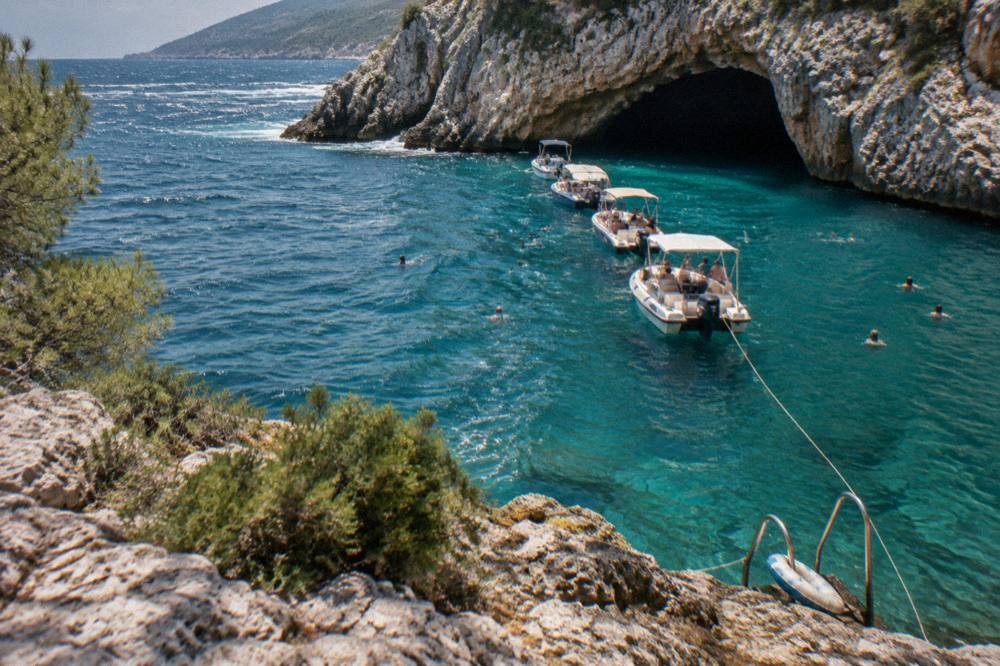 A group of speedboats anchored outside the Blue Cave while passengers swim in