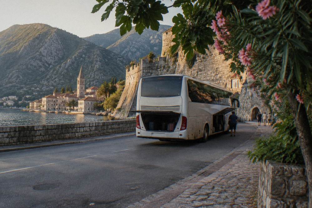 Tour coach parked beside the old stone walls of Kotor's Old Town