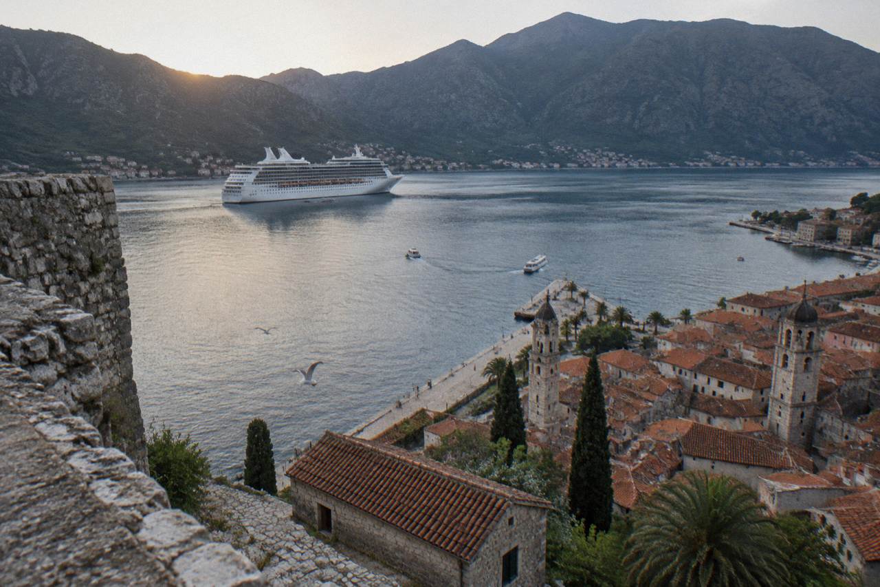 Cruise ship anchored in the Bay of Kotor with mountains rising behind the walled old town