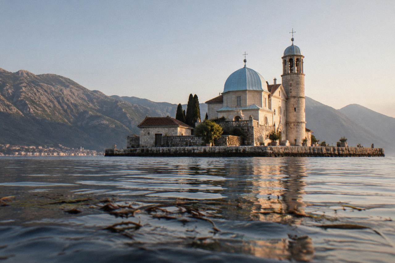 A small baroque church on a man-made island in the Bay of Kotor, seen from the water near Perast