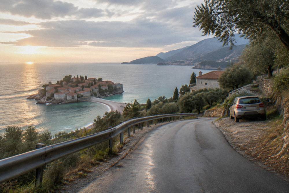 The coastal road curving above Sveti Stefan with the islet and mainland beach below