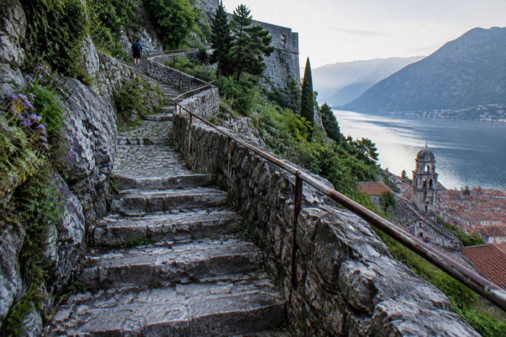 Stone stairway climbing the Kotor city walls toward the fortress above the bay