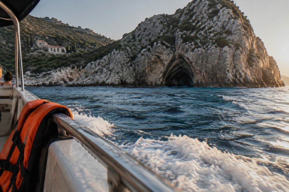 Speedboat crossing open water toward cliffs on a Boka Bay tour