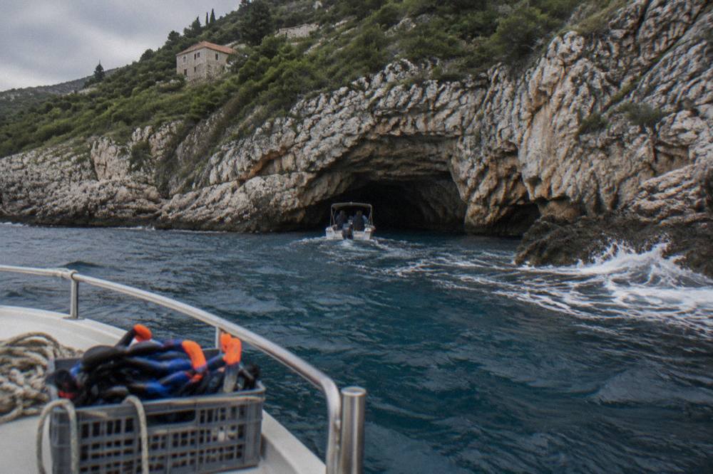 Speedboat approaching a rocky cave entrance on the Adriatic coast near the Bay of Kotor