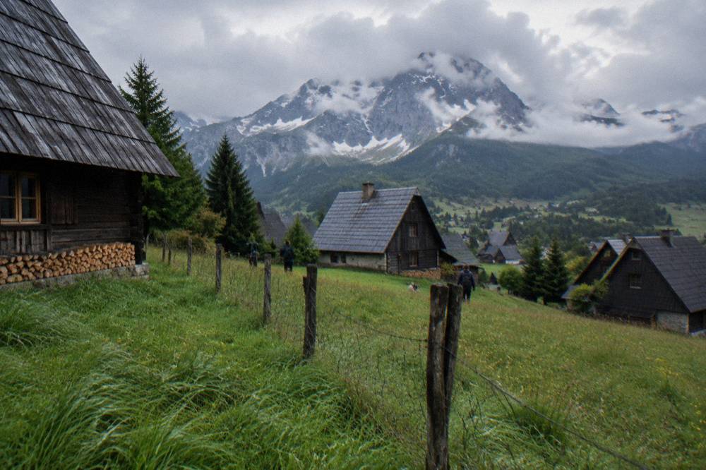 Wooden houses and green meadows at Zabljak under the peaks of Durmitor