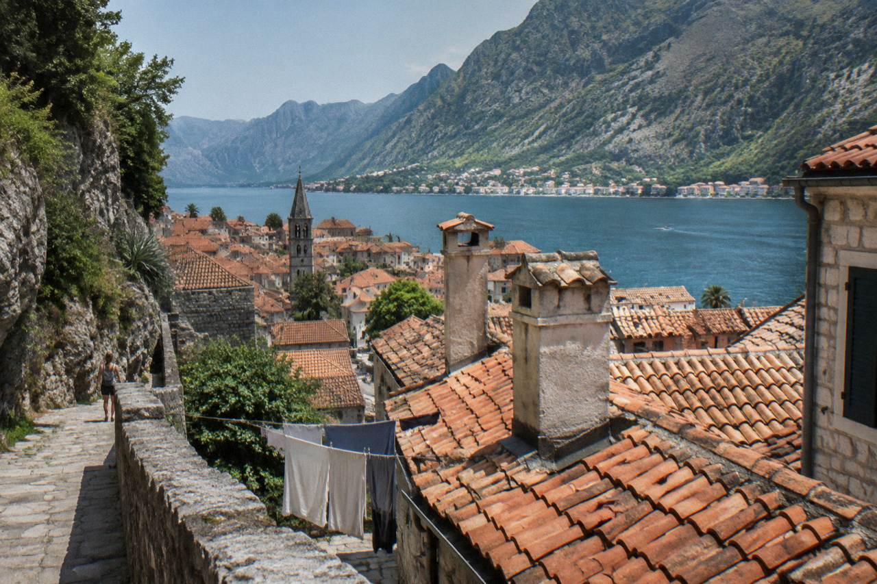 Rooftops of Kotor Old Town with the mountain wall of the bay rising behind them